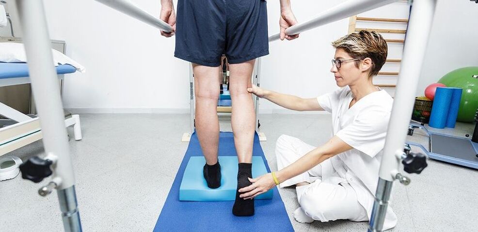 Fizioterapeut care instruiește pacientul cu artroză a genunchiului
